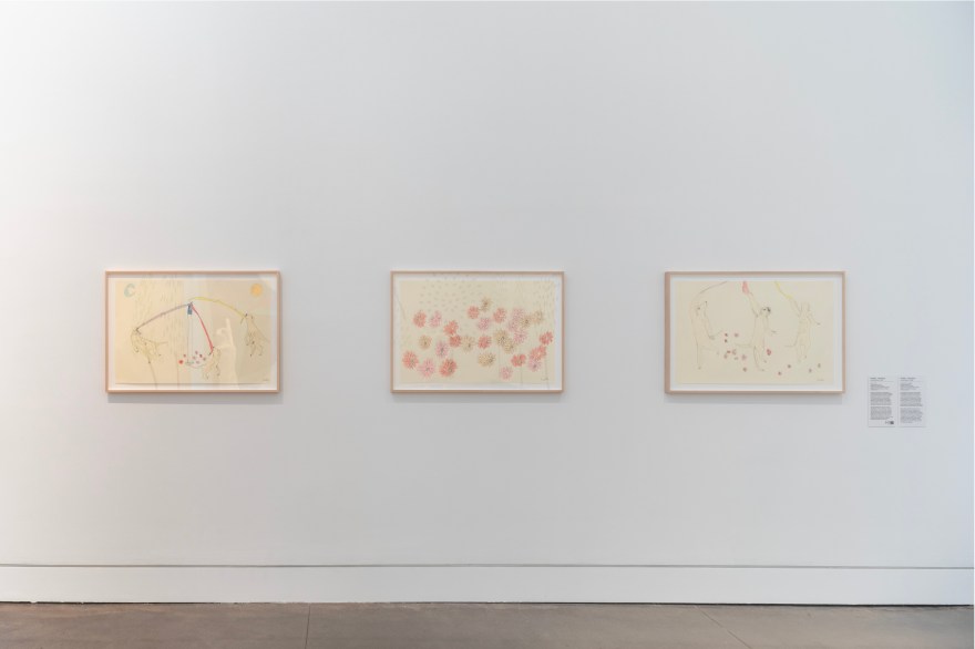 Three horizontally oriented framed drawings on a white gallery wall. They are done by ballpoint pen and crayon.